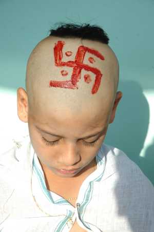 Hindu child with head shaven and red Swastika painted on it. Upanayana is a very popular Hindu-tradition, a Samskara or Sanskar (consecration). In Upanayana, along with the sacred thread-tying ceremony, child's hair are partially shaved for the purpose of Shikhabandhan. This is accompanied with a celebration.