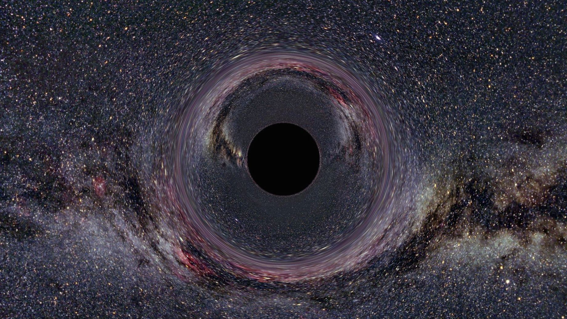 A simulated Black Hole of ten solar masses as seen from a distance of 600km with the Milky Way in the background (horizontal camera opening angle: 90°). Ute Kraus/Wikimedia Commons (CC BY-SA). https://commons.wikimedia.org/wiki/File:Black_Hole_Milkyway.jpg